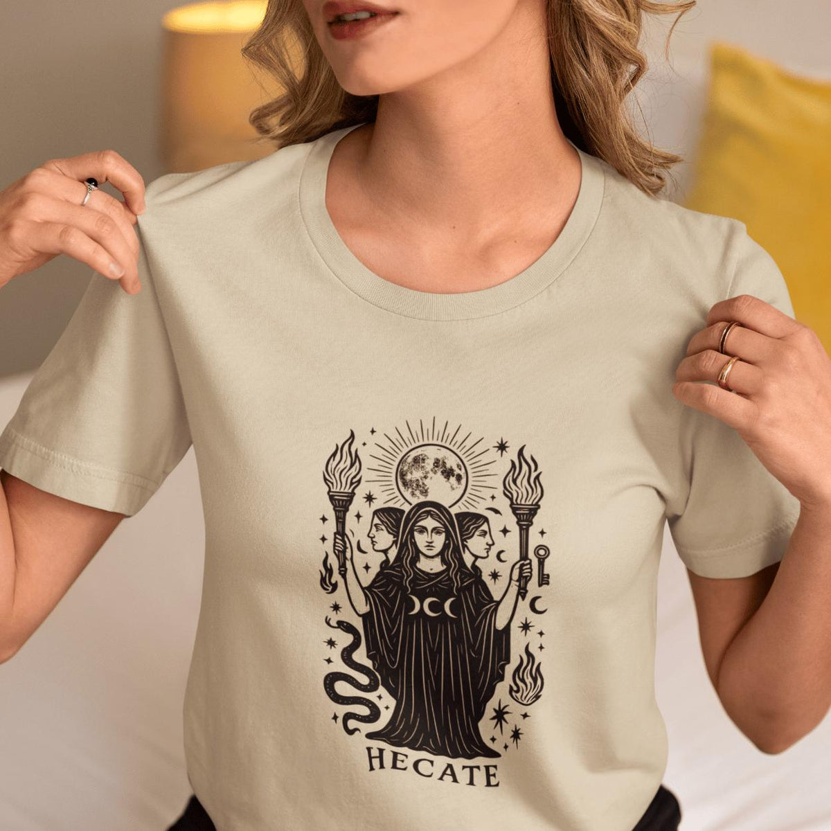 Hecate Greek mythology t-shirt in natural, front print of the triple moon goddess holding torches and a key beneath a full moon
